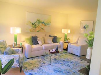 a living room with yellow walls and a blue rug at Forest Glen, Midland, MI, 48642